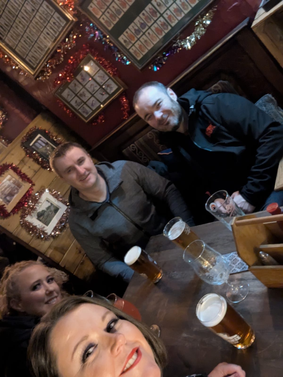 The four of us round a pub table under tinsel-framed pictures, York December 2024